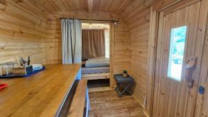 a wooden cabin with a desk and a bed in it at Camping Schlaffass Naima in Burg