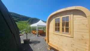 a small wooden shed with a table and a tent at Camping Schlaffass Naima in Burg