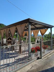 a gazebo with curtains and a fence at La casa di Pina in Latronico