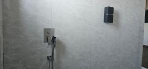 a shower in a bathroom with a tile wall at Cornerstone Hotel Arusha in Arusha +10 photos