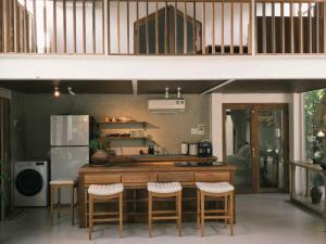a kitchen with a counter and some stools in it at Yên homestay in Phan Rang–Tháp Chàm