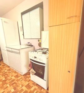 a kitchen with a white stove and a refrigerator at Antarut Garden House in Antarut