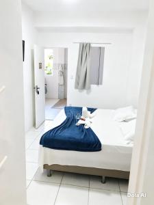 a white bedroom with a bed with a blue blanket at Pousada Mel in Praia do Forte +77 photos