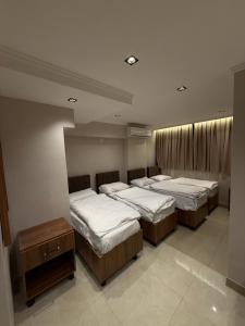 a group of four beds in a room at فندق وفادة الزهراء in Baghdād