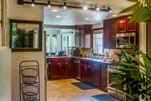a large kitchen with wooden cabinets and a sink at Pool & Yard Games! Group Retreat in La Quinta in La Quinta