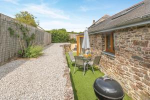 a backyard with a grill and a table and chairs at 2 Bed in Bideford oc-32240 in Parkham