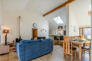 a living room with a blue couch and a dining room at 2 Bed in Bideford oc-32240 in Parkham