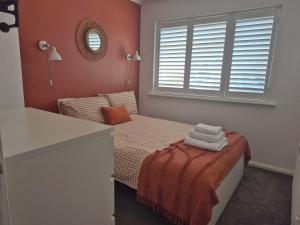 a small bedroom with a bed and a mirror at Seaside House Broadstairs by the Beach with Parking in Broadstairs
