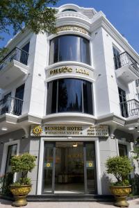 a white building with a sunburst hotel at Sunrise Hotel Phước Kim in Bạc Liêu