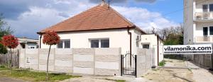 a white house with a gate and a fence at Vila Kele in Tvrdošovce