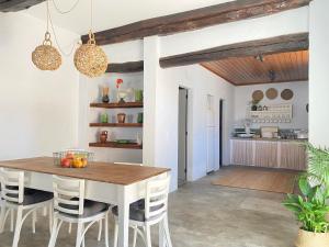 a kitchen and dining room with a wooden table and chairs at Casa do Chafariz in Torres Vedras