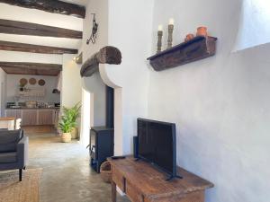 a living room with a tv and a wooden table at Casa do Chafariz in Torres Vedras
