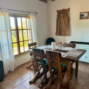 a dining room with a wooden table and chairs at Selene Malen 5 in Villa Pehuenia