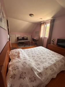 a bedroom with a bed with a white blanket at Maison Fleurie in Aubertin