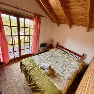 a teddy bear laying on a bed in a bedroom at Selene Malen 5 in Villa Pehuenia