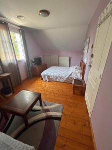 a bedroom with two beds and a table in it at Maison Fleurie in Aubertin