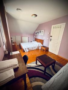 a bedroom with a bed and a table and a couch at Maison Fleurie in Aubertin