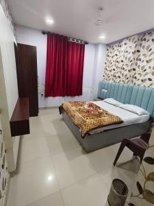 a bedroom with a bed and a red curtain at Hotel Relax Inn in Madikeri