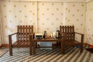 two chairs sitting next to a wooden table with at The Jungle Enclave Boho in Khilchipur