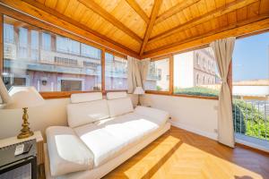 a white couch in a room with large windows at Villa al Duomo Taormina - Suite & Rooms in Taormina