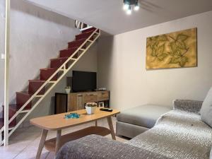 a living room with a couch and a table and a staircase at La Casa Nuova in Chios