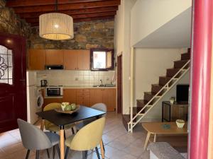 a kitchen and dining room with a table and a staircase at La Casa Nuova in Chios