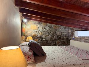 a bed in a room with a stone wall at La Casa Nuova in Chios