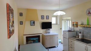a kitchen with a fireplace and a tv on the wall at Il Nido nel Borgo in Piediluco
