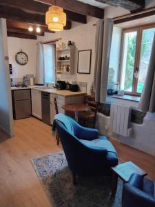 a living room with a couch and a kitchen at La Petite Grange in Langourla +8 photos