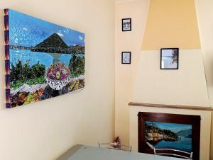 a living room with a fireplace with a painting on the wall at Il Nido nel Borgo in Piediluco