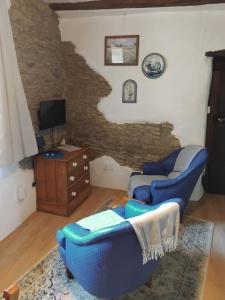 a living room with a blue couch and a tv at La Petite Grange in Langourla