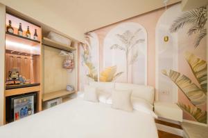a bedroom with a white bed with plants on the wall at Villa al Duomo Taormina - Suite & Rooms in Taormina