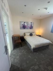 a bedroom with a bed and a chair at The Goodlife Guesthouse in Harwich