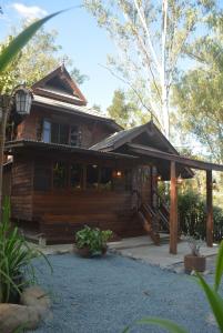 a wooden house with a porch and a staircase at Sunny Mountain in Ban Nong Hoi