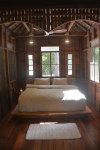 a bedroom with a large bed in a room with windows at Sunny Mountain in Ban Nong Hoi