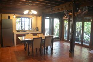 a kitchen with a table and chairs and a refrigerator at Sunny Mountain in Ban Nong Hoi