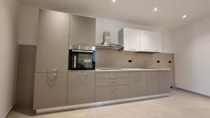 a large kitchen with white cabinets and a sink at Casa vacanze Donna Santa in San Marco dʼAlunzio