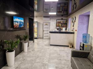a coffee shop with a counter and potted plants at Avangard Hotel in Almaty