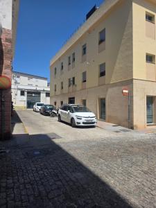 a parking lot with cars parked in front of a building at Casa Andrea in Puerto Real