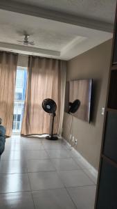 a living room with a fan and a window at Espaço ling in João Pessoa