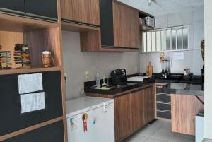 a kitchen with wooden cabinets and a white refrigerator at Espaço ling in João Pessoa