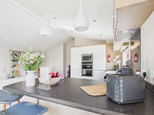 a kitchen with a table with a vase of flowers at Pinehurst, 65 Golf View Lodge in Jedburgh