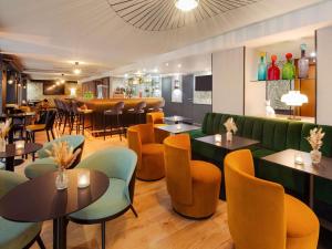 a restaurant with tables and chairs and a bar at Mercure Lyon Centre Plaza République in Lyon