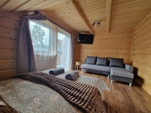a bedroom with a bed and a couch and a window at Pokoje goscinne u Jozka in Chochołów