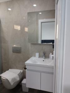 a bathroom with a toilet and a sink and a mirror at Fethiye Apart Otel in Fethiye +98 photos