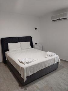 a bed with a black headboard and white sheets at Fethiye Apart Otel in Fethiye