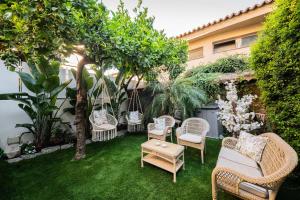 a patio with chairs and a table and trees at Villa al Duomo Taormina - Suite & Rooms in Taormina