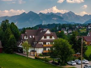 a house in a village with mountains in the background at Willa Litworowy Staw in Bukowina Tatrzańska