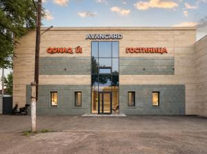 a building with a sign on the front of it at Avangard Hotel in Almaty