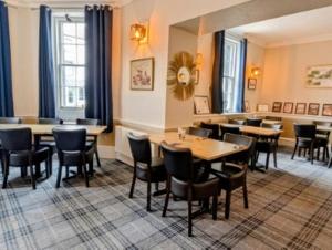 a restaurant with tables and chairs in a room at Graham Arms Inn in Longtown